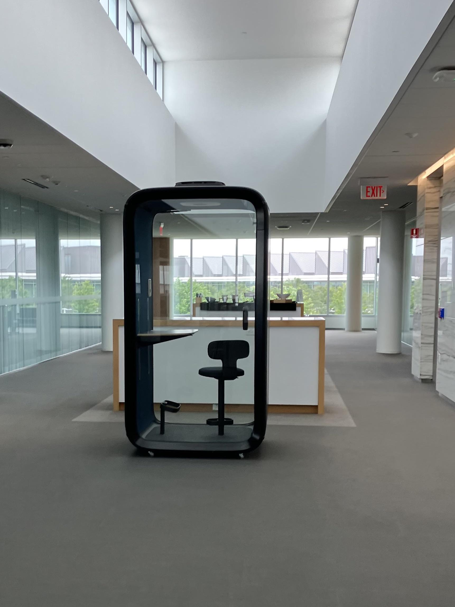 Before image: An office cubicle in a larger office space with lots of windows. The image is very dull and lifeless, being mostly gray tones.